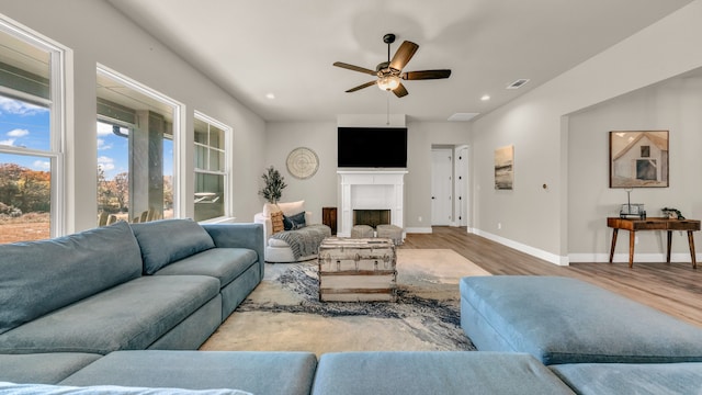 living room with light wood-type flooring and ceiling fan