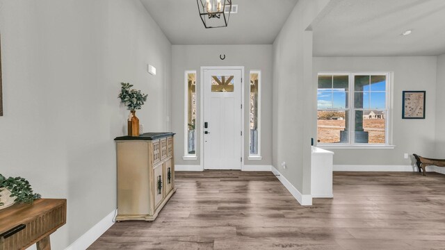 living room with plenty of natural light, light hardwood / wood-style floors, and ceiling fan with notable chandelier