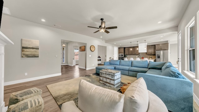 living room featuring ceiling fan and dark wood-type flooring