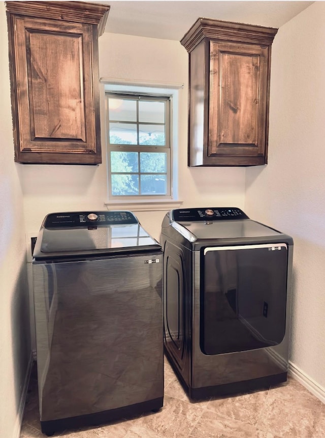 washroom featuring washer and dryer and cabinets