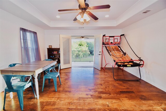 dining area featuring a raised ceiling, ceiling fan, ornamental molding, and hardwood / wood-style floors