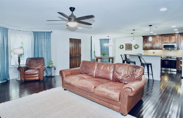 living room with dark wood-type flooring and ceiling fan