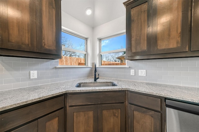 kitchen featuring decorative backsplash, a sink, and dark brown cabinetry