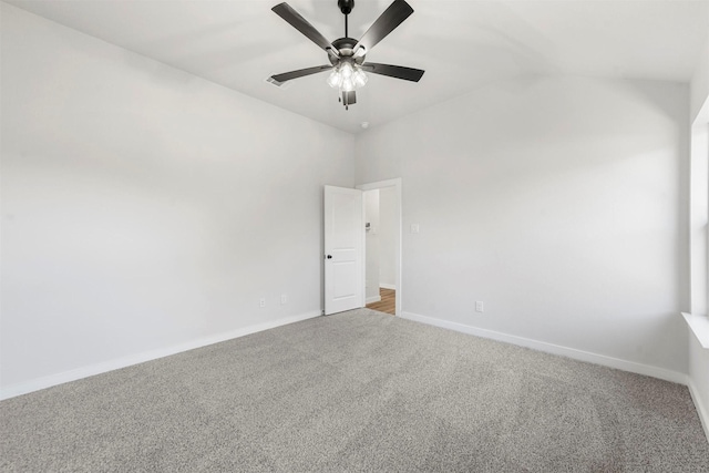 carpeted spare room featuring baseboards and a ceiling fan