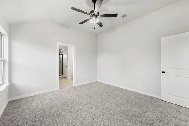 unfurnished bedroom featuring light carpet, baseboards, visible vents, a ceiling fan, and lofted ceiling