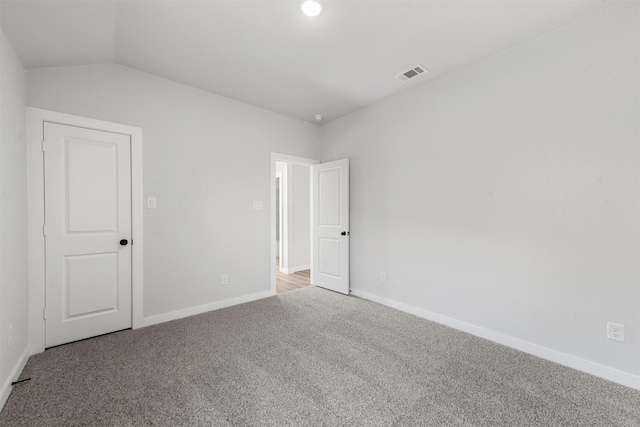 unfurnished room with lofted ceiling, baseboards, visible vents, and carpet flooring