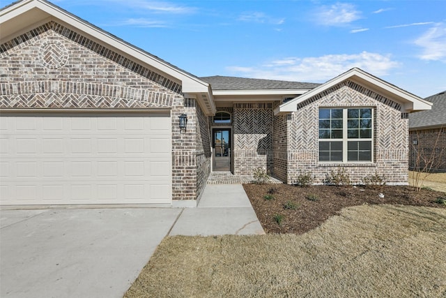 view of front of house featuring a garage, brick siding, driveway, and roof with shingles