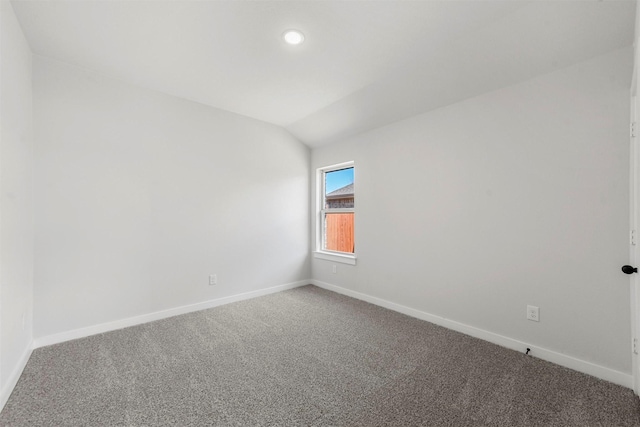 empty room featuring carpet floors, recessed lighting, vaulted ceiling, and baseboards