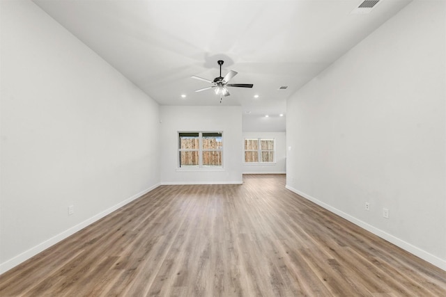 unfurnished living room featuring ceiling fan, wood finished floors, visible vents, and baseboards