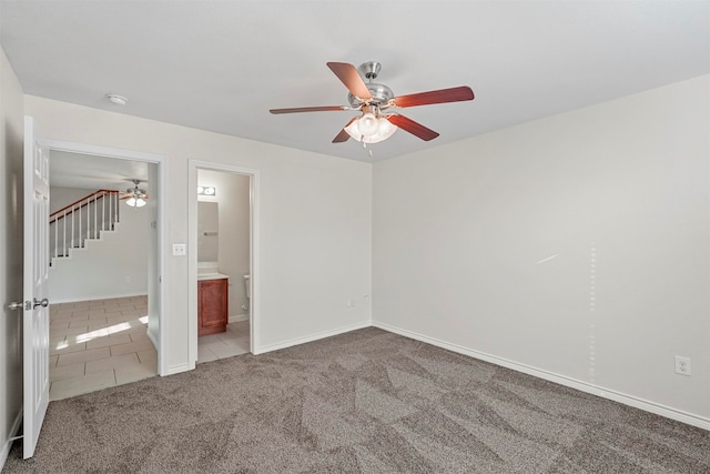 unfurnished bedroom with ceiling fan, carpet, and ensuite bath