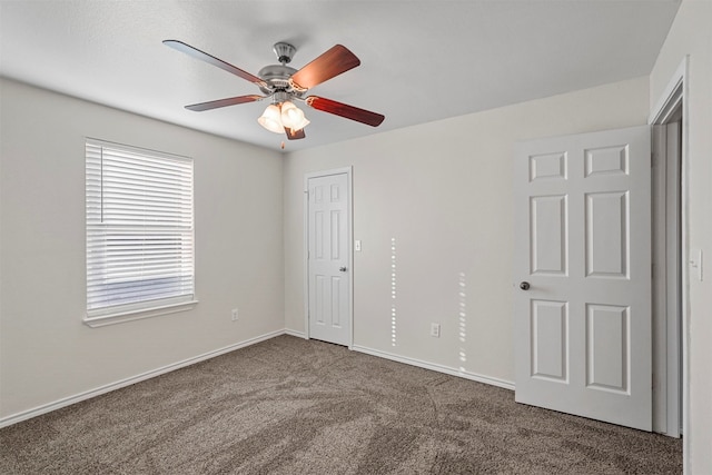 unfurnished bedroom featuring ceiling fan and dark carpet