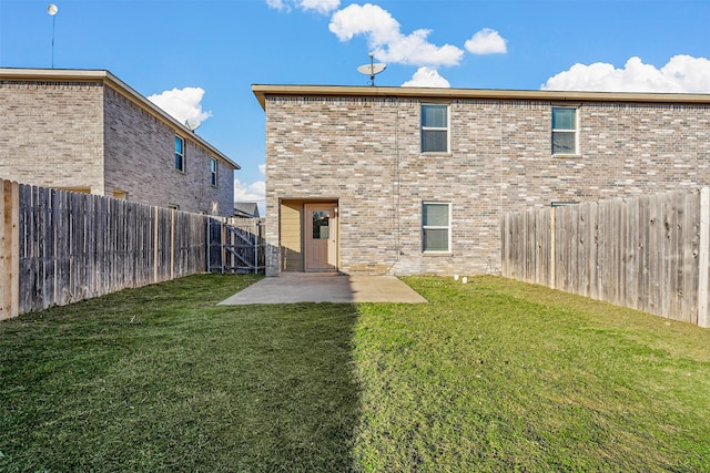 back of house with a lawn and a patio