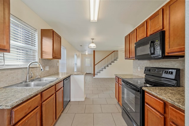 kitchen featuring pendant lighting, sink, light tile patterned floors, black appliances, and kitchen peninsula