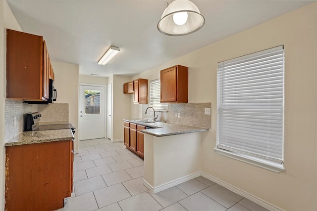 kitchen featuring light stone counters, sink, and light tile patterned floors