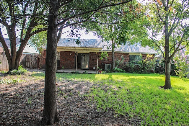 back of house featuring a patio area and a lawn