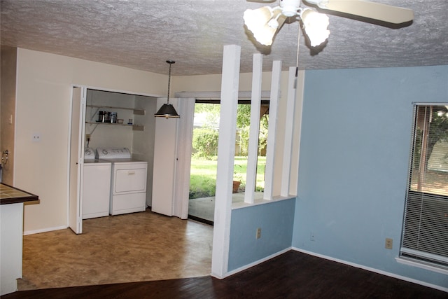 interior space with dark hardwood / wood-style flooring, ceiling fan, washing machine and dryer, and a textured ceiling