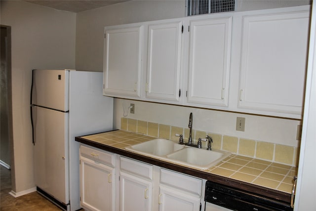 kitchen with dishwashing machine, white refrigerator, white cabinetry, and sink