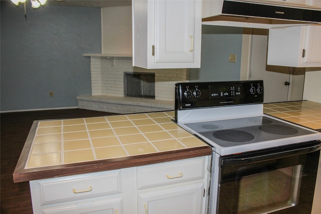 kitchen with tile countertops, decorative backsplash, white cabinetry, and white electric stove