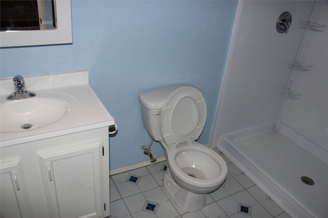 bathroom with a shower, vanity, tile patterned floors, and toilet