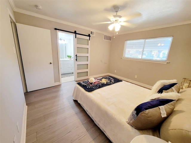 bedroom with a barn door, light hardwood / wood-style flooring, ceiling fan, and crown molding