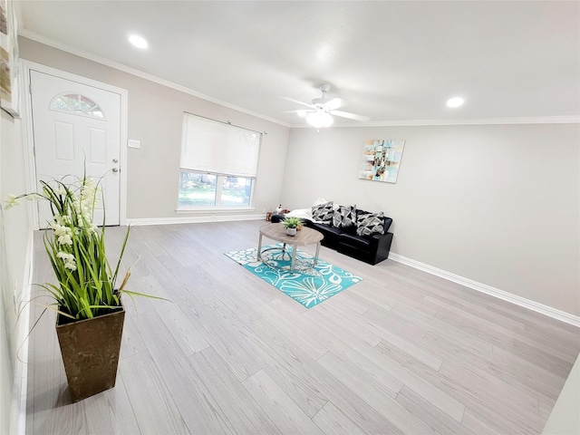 living room featuring crown molding, light hardwood / wood-style flooring, and ceiling fan with notable chandelier