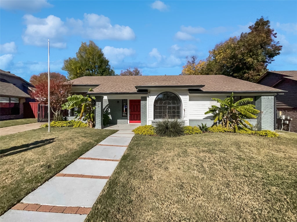 ranch-style home with a front lawn