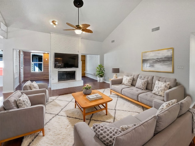 living room with a fireplace, ceiling fan, light hardwood / wood-style flooring, and high vaulted ceiling