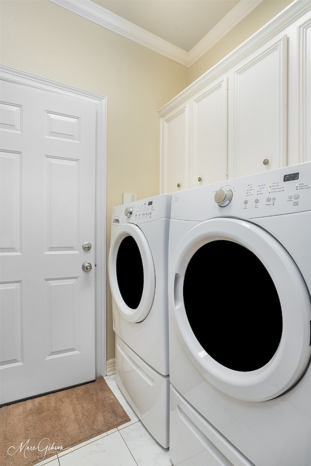 washroom with cabinets, washing machine and dryer, and ornamental molding