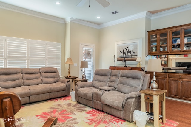 living room featuring ornamental molding, ceiling fan, and light hardwood / wood-style flooring