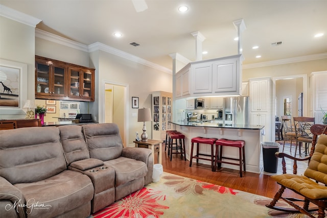 living room with hardwood / wood-style flooring and ornamental molding