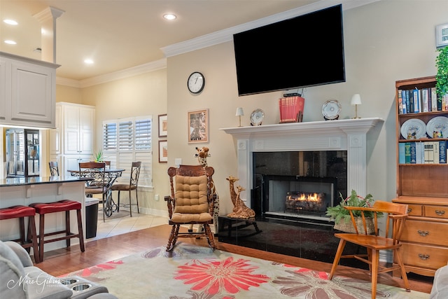 living room with crown molding and a tile fireplace