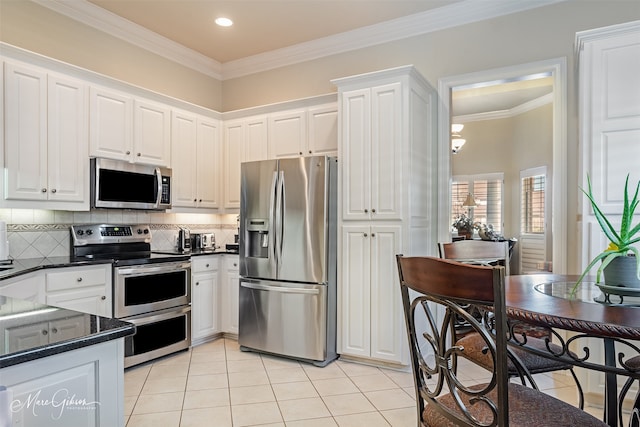 kitchen featuring stainless steel appliances, light tile patterned flooring, white cabinets, and decorative backsplash