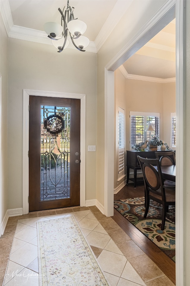 tiled entryway with ornamental molding and a notable chandelier