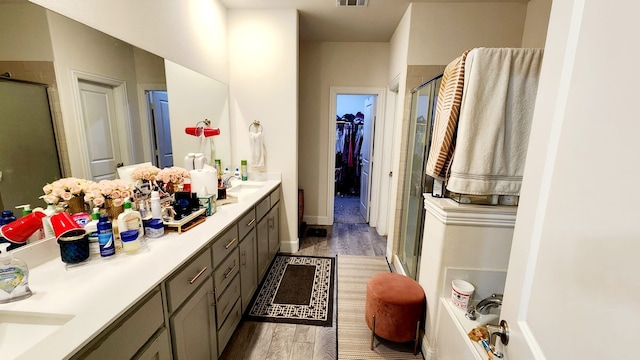 bathroom with vanity, wood-type flooring, and walk in shower