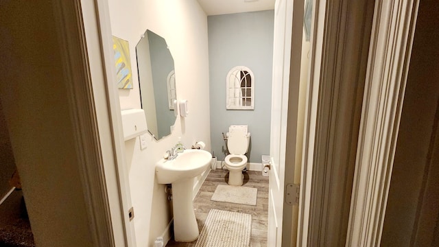 bathroom featuring hardwood / wood-style flooring and toilet