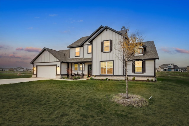 modern farmhouse style home with a garage and a lawn