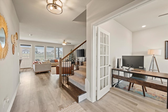 staircase with wood-type flooring and ceiling fan