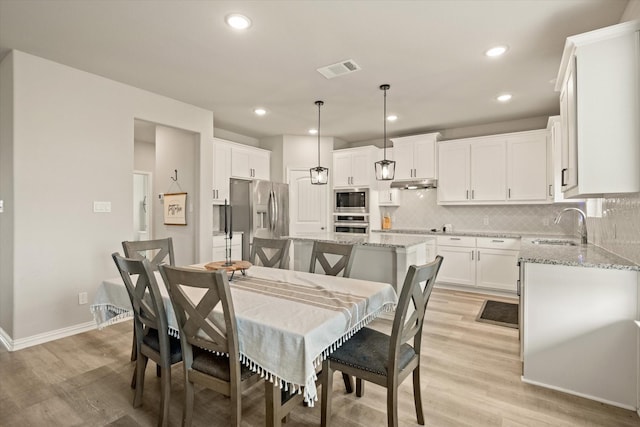 dining room with light hardwood / wood-style floors and sink