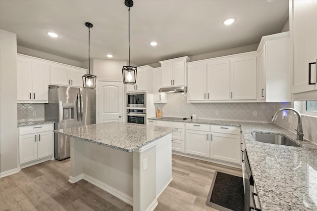 kitchen with a center island, appliances with stainless steel finishes, white cabinets, and sink