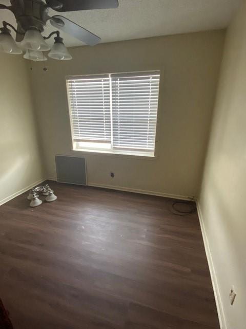 unfurnished room with ceiling fan and dark wood-type flooring