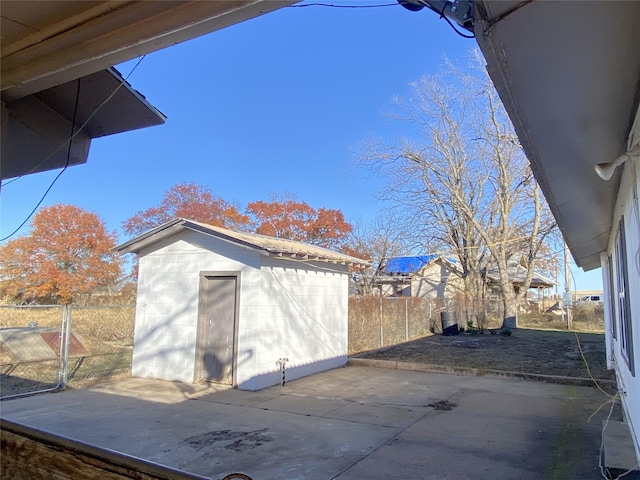 view of side of home with a patio area and a storage shed