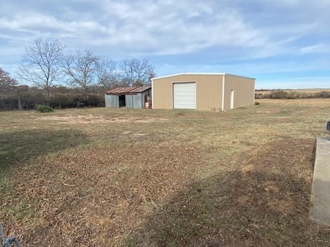 view of yard featuring a garage and an outdoor structure