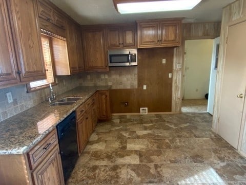 kitchen with dishwasher, backsplash, stone counters, and sink