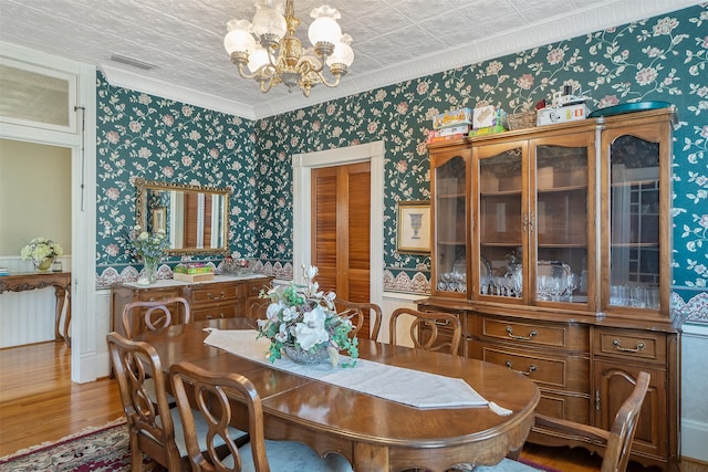 dining area featuring wallpapered walls, a chandelier, radiator heating unit, wood finished floors, and an ornate ceiling