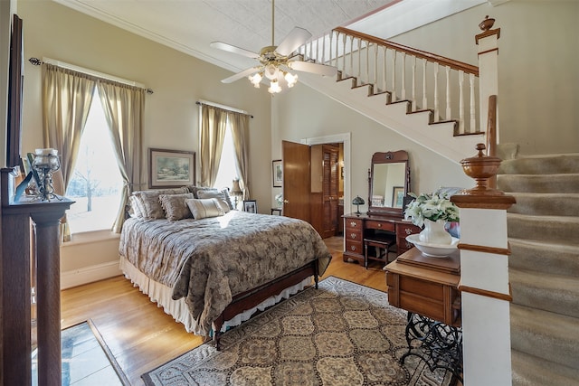 bedroom featuring ceiling fan, light hardwood / wood-style flooring, and ornamental molding