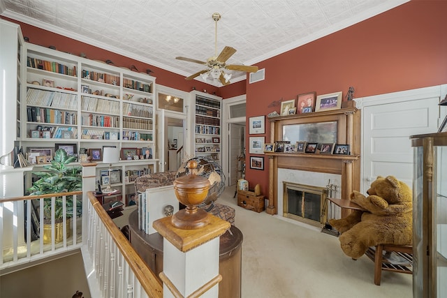 sitting room featuring carpet flooring, ceiling fan, and ornamental molding