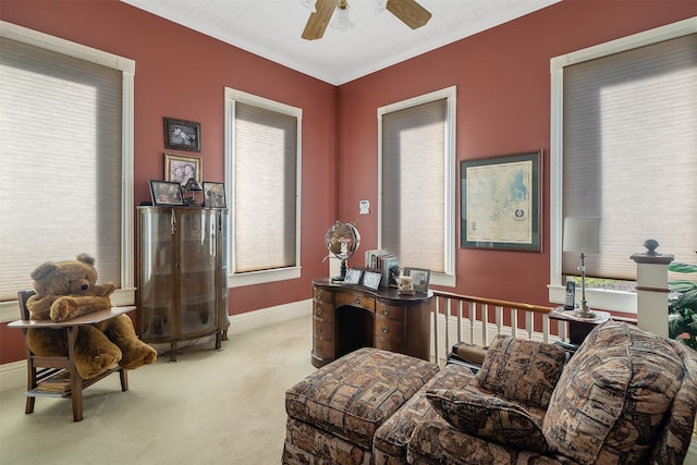 sitting room featuring ceiling fan, baseboards, and light carpet