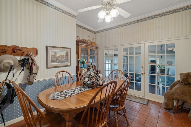 tiled dining space featuring french doors, wallpapered walls, crown molding, and ceiling fan