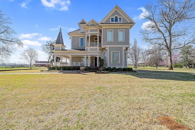 victorian-style house featuring a porch and a front yard