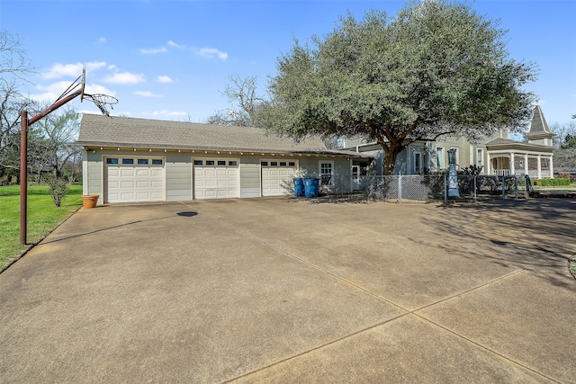 view of front of property featuring a shingled roof, a garage, and fence